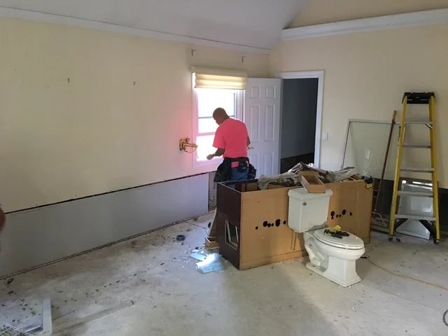 Bathroom under renovation with drywall installation, chair rail trim, and new electrical outlets