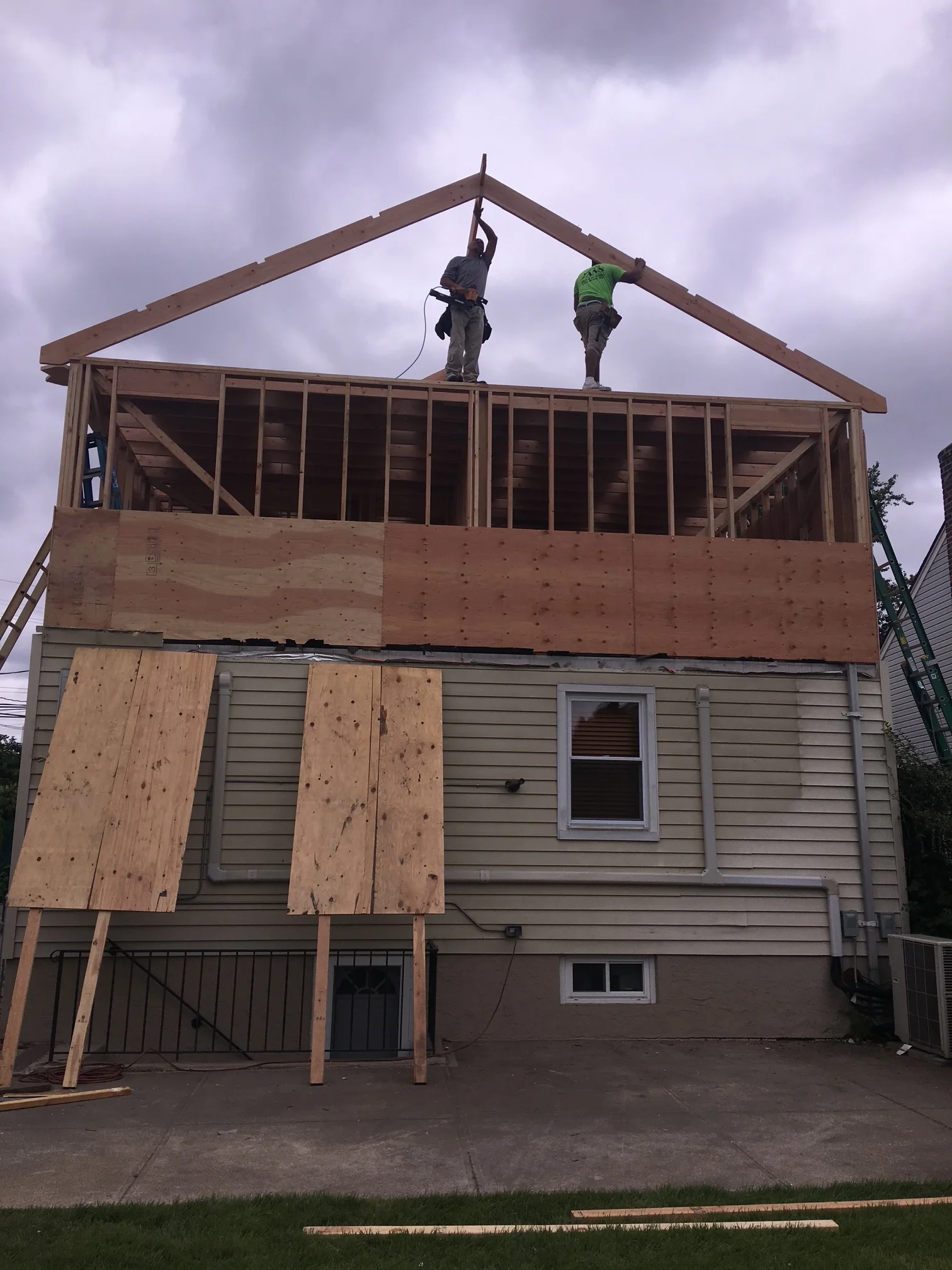 Second story framing with roof trusses, plywood sheathing, and window openings under construction