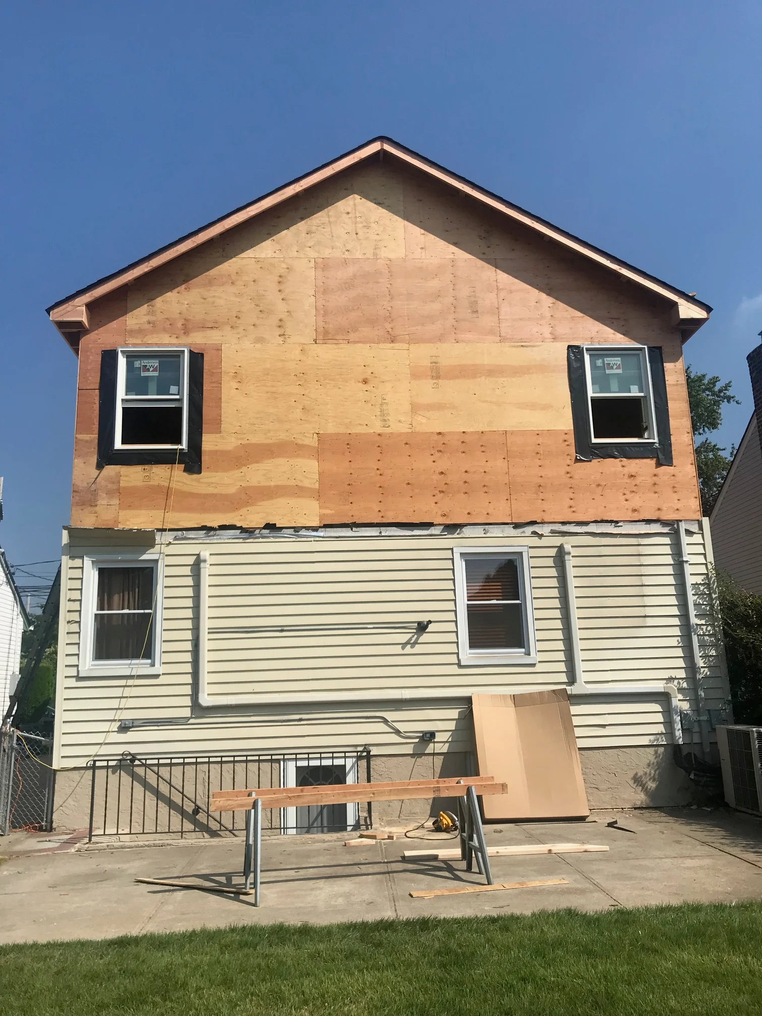 Second story framing with OSB sheathing, new windows, and peaked roof on residential home addition